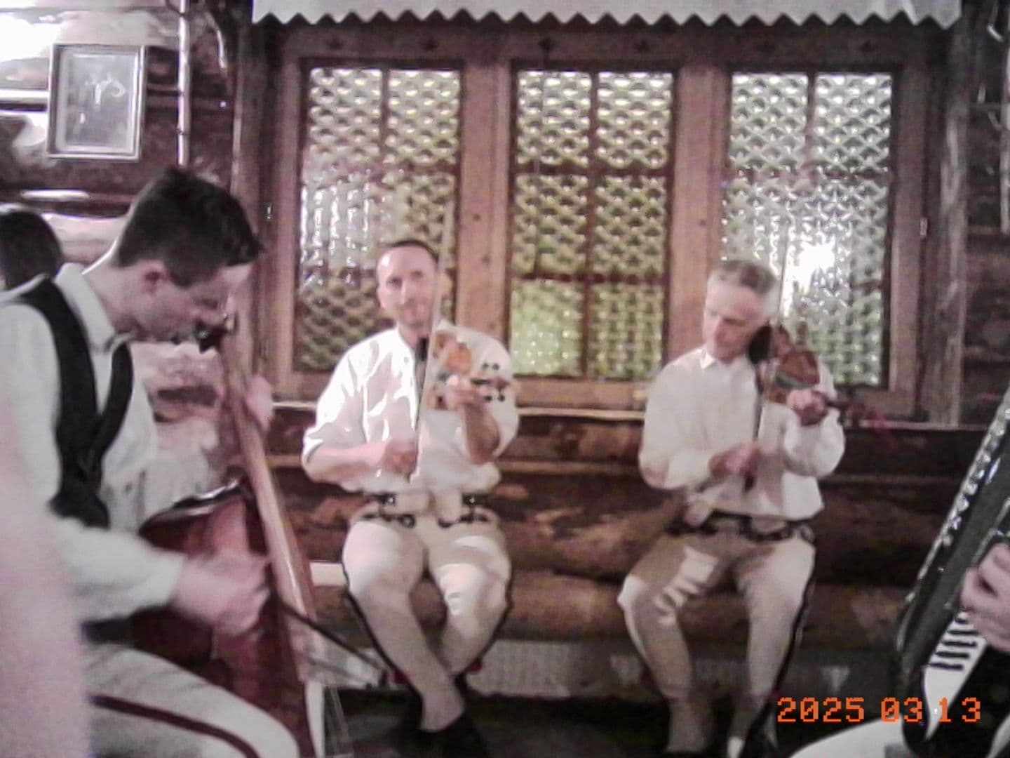 Musicians in traditional dress playing in a wooden highland restaurant